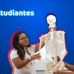 Estudiantes de CECYTE Guanajuato participan en una clase práctica sobre anatomía, sosteniendo un modelo de esqueleto humano mientras observan y aprenden.
