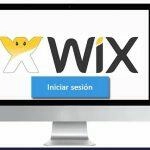 Pantalla de inicio de sesión de Wix en un monitor de computadora, mostrando el logo de Wix y un botón azul con la opción para iniciar sesión.